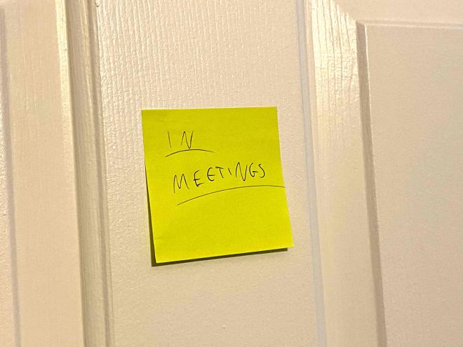Photo of a post-it on my door that says IN MEETINGS