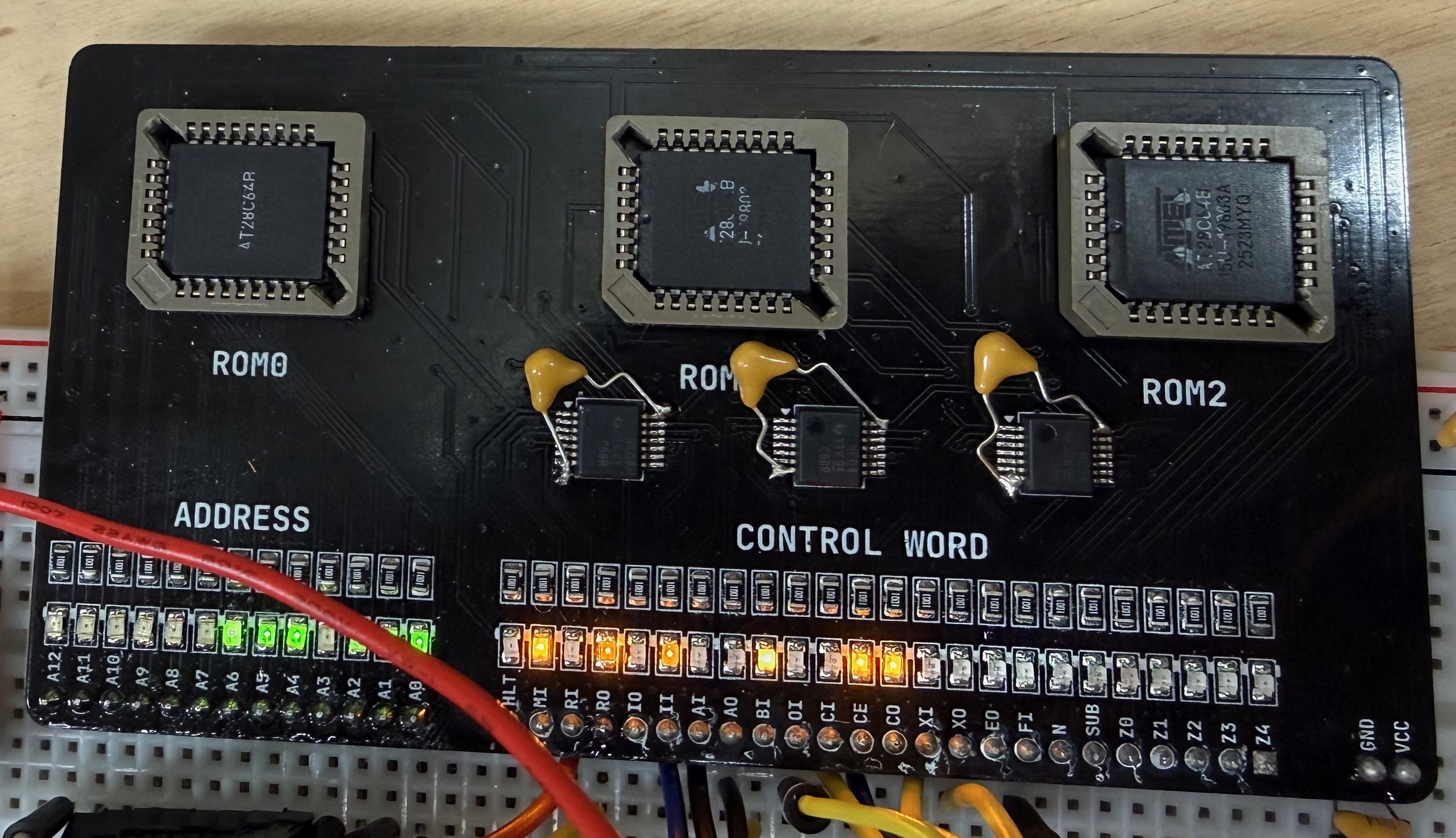 Photo of the completed control module PCB. Three EEPROMs in their sockets are visible, along with the 3 shift registers with their bodged decoupling capacitors. Some of the LEDs are glowing.
